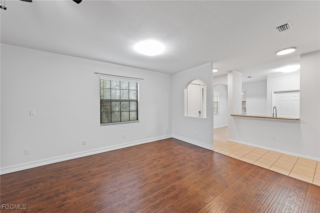 14764 Pinnacle Place, Unit 65 Naples, FL 34119 - Photo 11 of 50 wooden floor in an empty room with a window