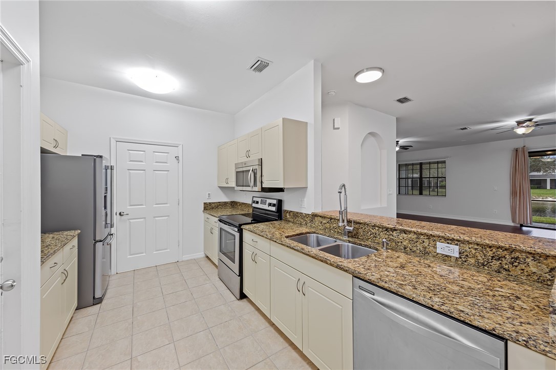 14764 Pinnacle Place, Unit 65 Naples, FL 34119 - Photo 17 of 50 a kitchen with granite countertop a sink stove and refrigerator