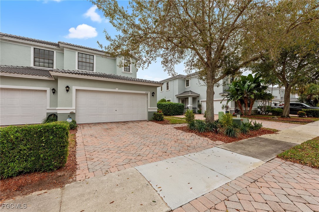 14764 Pinnacle Place, Unit 65 Naples, FL 34119 - Photo 2 of 50 a front view of a house with garden