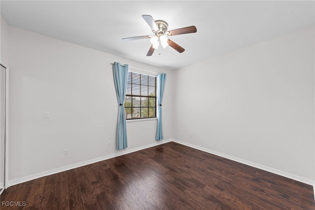 14764 Pinnacle Place, Unit 65 Naples, FL 34119 - Photo 22 of 50 an empty room with wooden floor chandelier and windows