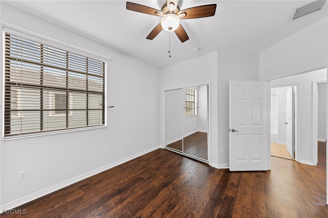 14764 Pinnacle Place, Unit 65 Naples, FL 34119 - Photo 26 of 50 a view of an empty room with wooden floor and a window