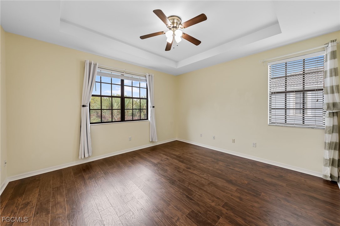 14764 Pinnacle Place, Unit 65 Naples, FL 34119 - Photo 27 of 50 an empty room with wooden floor and windows
