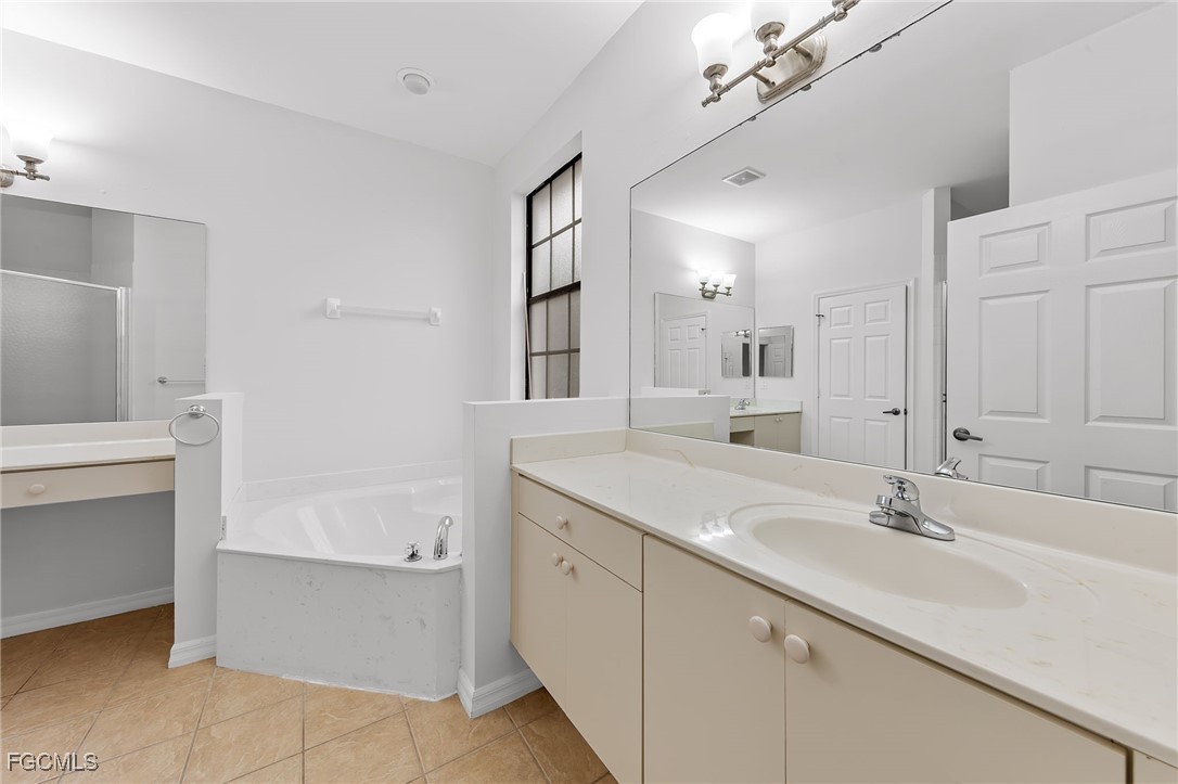 14764 Pinnacle Place, Unit 65 Naples, FL 34119 - Photo 29 of 50 a bathroom with a sink vanity and mirror