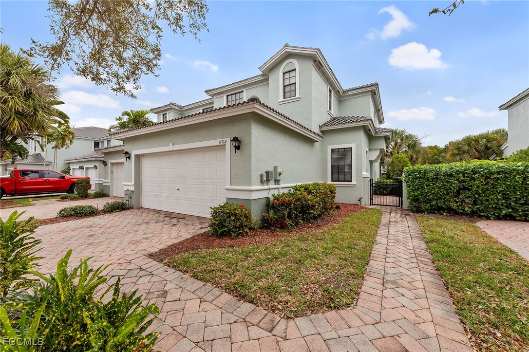 14764 Pinnacle Place, Unit 65 Naples, FL 34119 - Photo 3 of 50 a front view of a house with a yard and garage