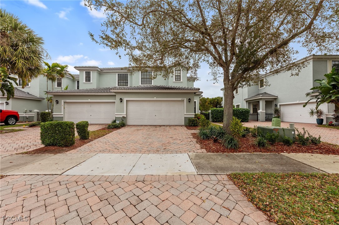 14764 Pinnacle Place, Unit 65 Naples, FL 34119 - Photo 41 of 50 a front view of a house with a yard and a garage