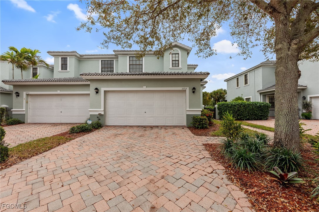 14764 Pinnacle Place, Unit 65 Naples, FL 34119 - Photo 42 of 50 a front view of a house with a yard and a garage