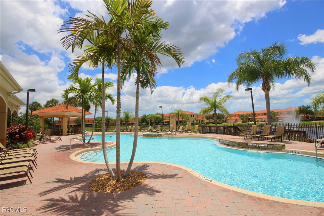 14764 Pinnacle Place, Unit 65 Naples, FL 34119 - Photo 45 of 50 a view of a swimming pool with a table and chairs