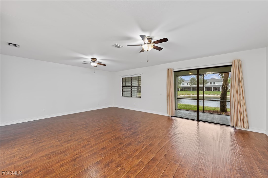 14764 Pinnacle Place, Unit 65 Naples, FL 34119 - Photo 7 of 50 a view of empty room with wooden floor and fan