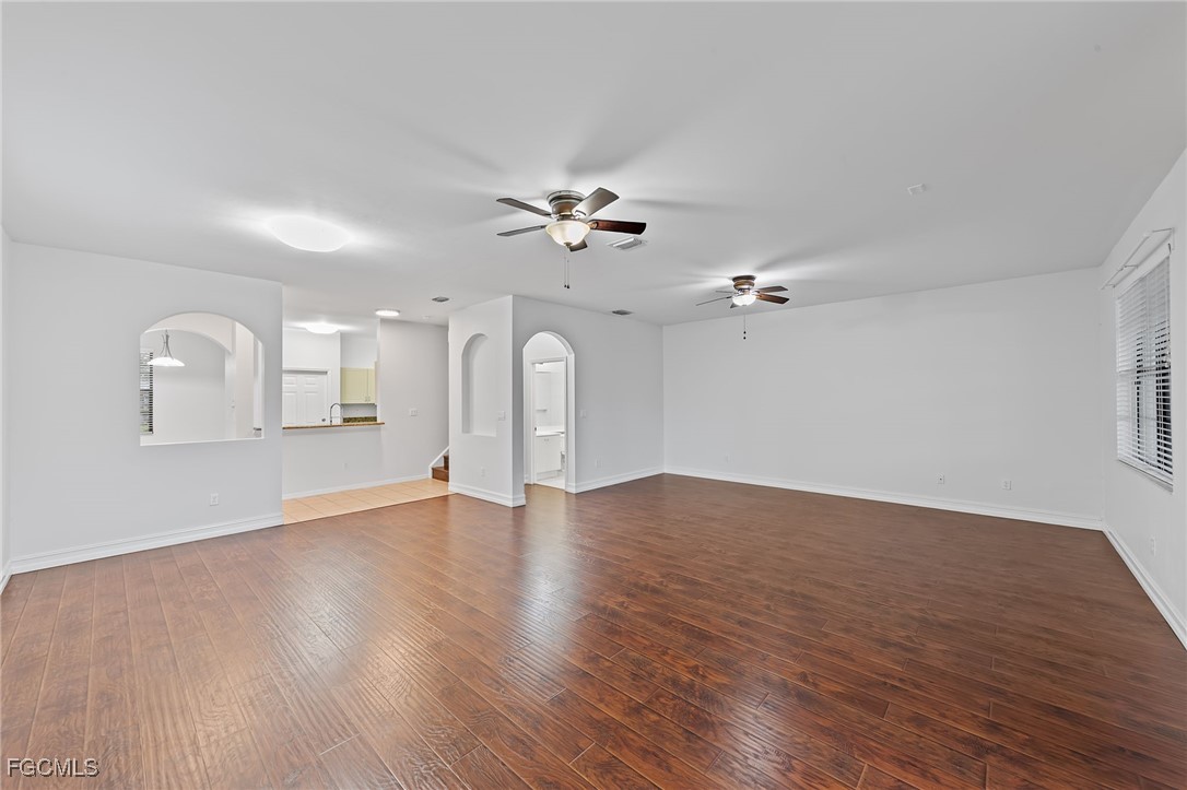 14764 Pinnacle Place, Unit 65 Naples, FL 34119 - Photo 8 of 50 an empty room with wooden floor ceiling fan and window