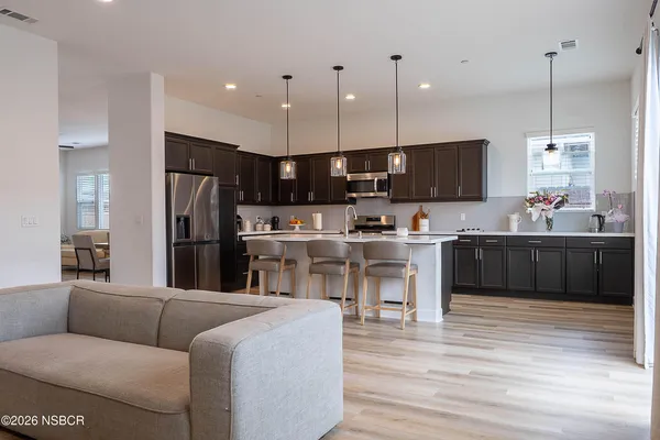 a kitchen with stainless steel appliances kitchen island granite countertop a refrigerator and a stove top oven