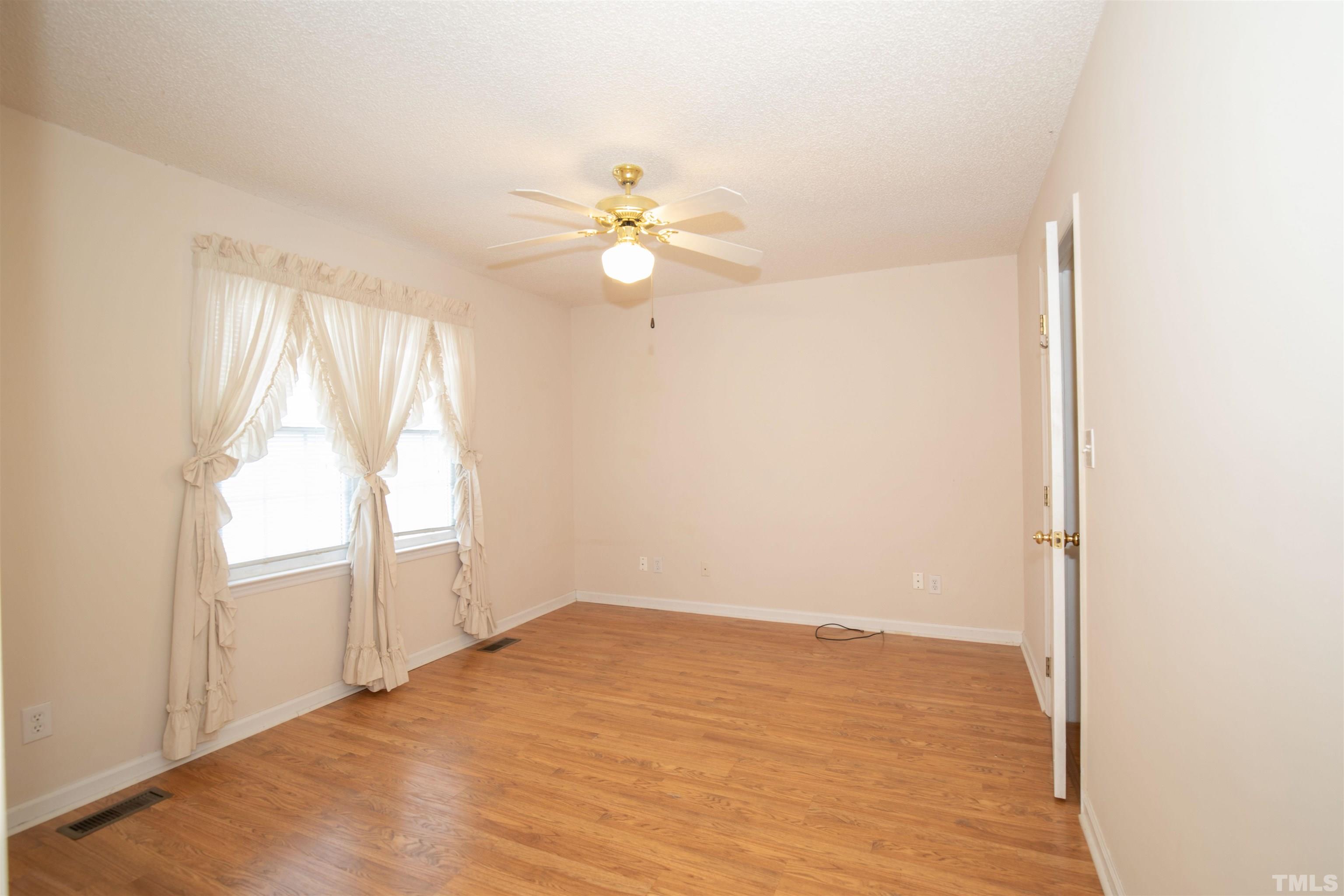 300 Sanders Road Benson, NC 27504 - Photo 13 of 24 an empty room with a window and a ceiling fan