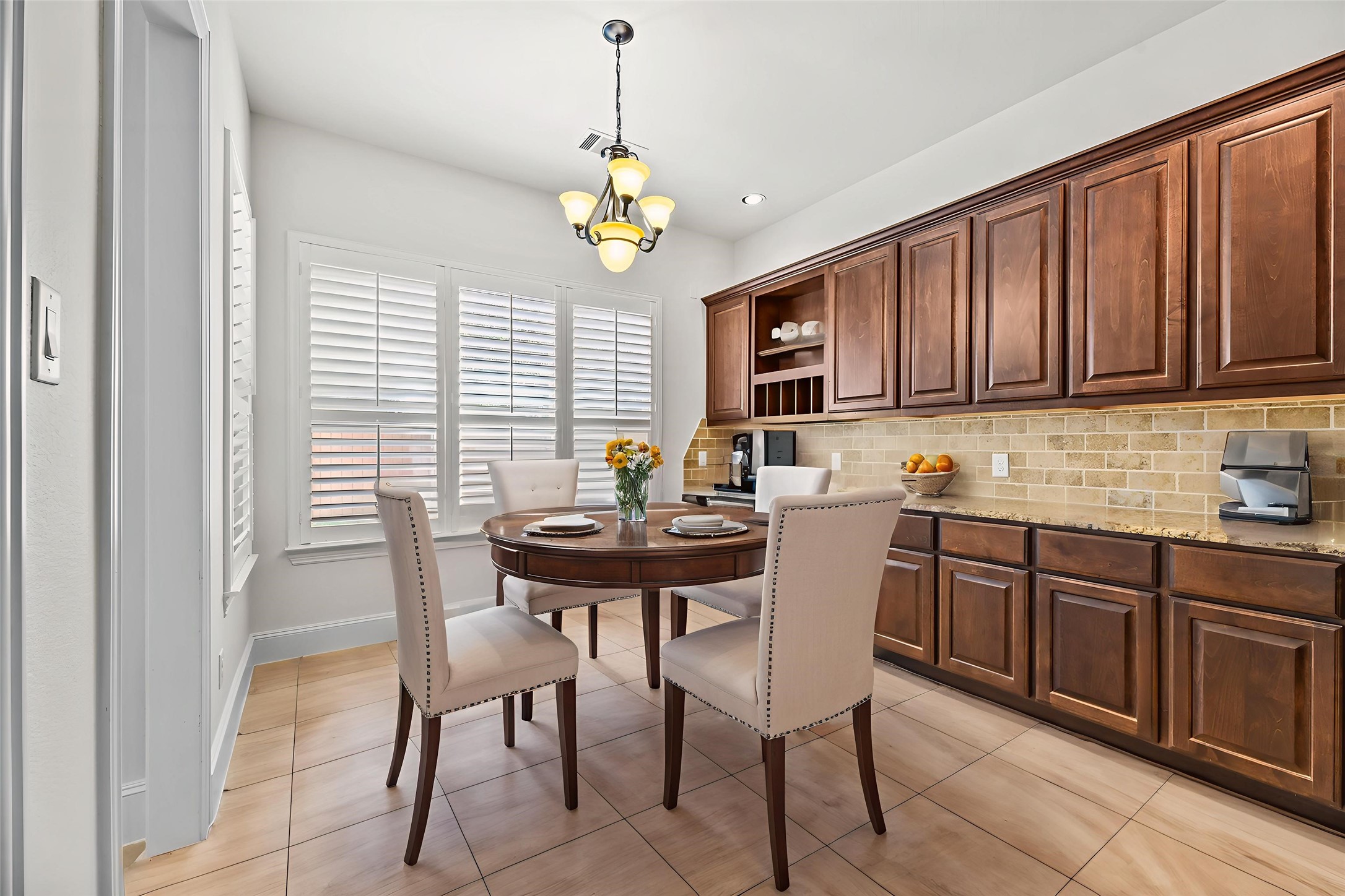 4510 Cedarfield Road Katy, TX 77494 - Photo 5 of 24 The spacious breakfast area, nestled between the kitchen and living room, easily fits a large table—perfect for family meals. The built-in desk with matching cabinetry adds a charming touch of function and style.