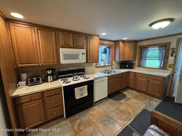 a kitchen with stainless steel appliances granite countertop a refrigerator stove top oven and sink