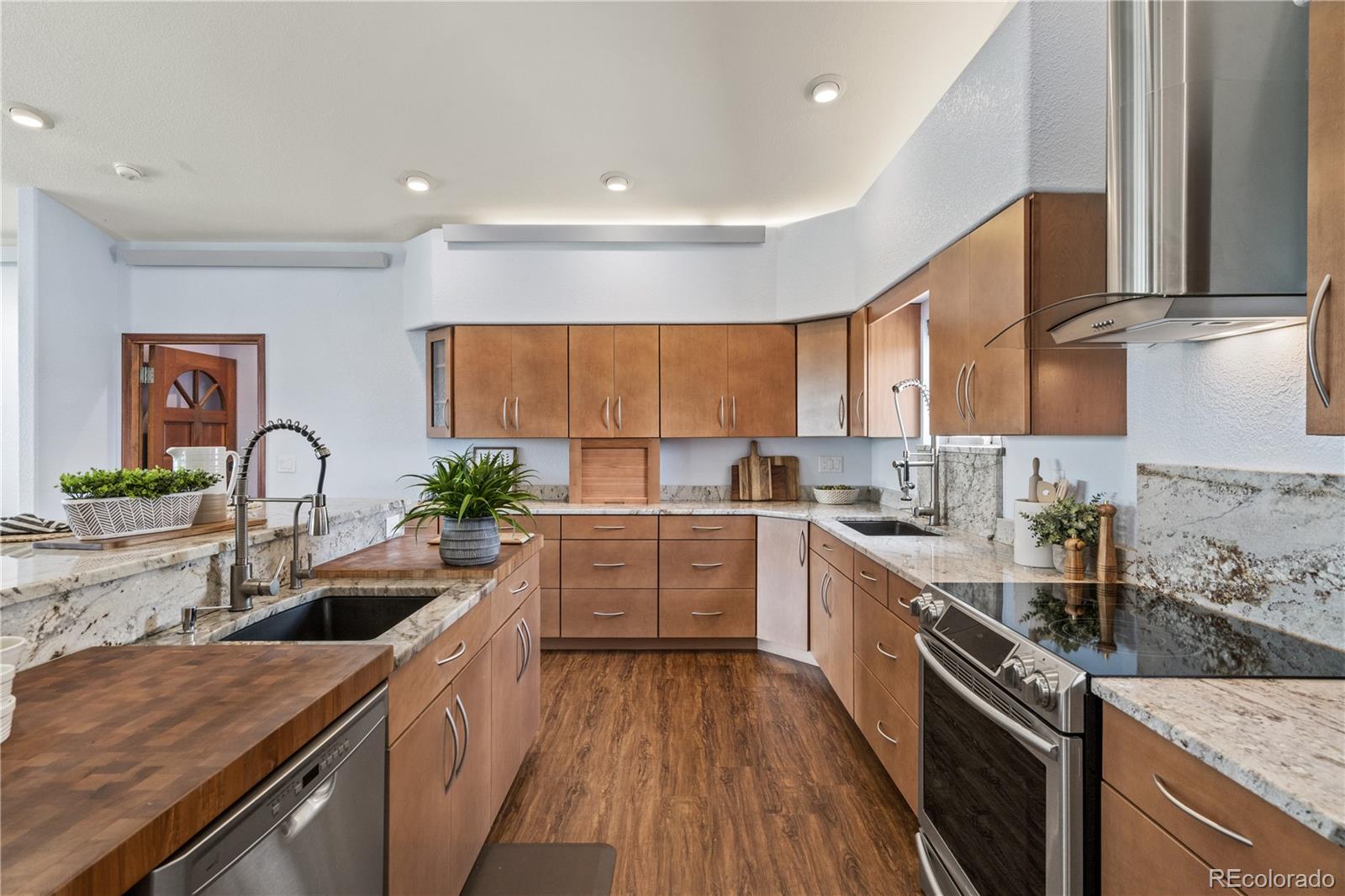 17622 County Road 1 Berthoud, CO 80513 - Photo 12 of 37 a kitchen with stainless steel appliances a sink dishwasher a stove top oven a refrigerator with wooden floors and cabinets