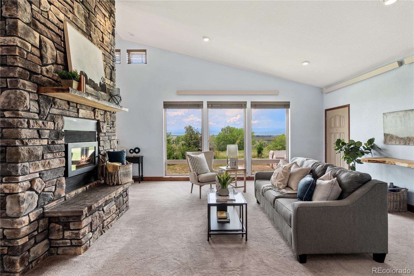 17622 County Road 1 Berthoud, CO 80513 - Photo 14 of 37 a living room with furniture large windows and a fireplace