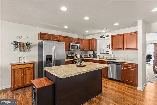 a kitchen with stainless steel appliances granite countertop a refrigerator a stove and a sink