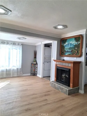 a view of empty room with wooden floor and fireplace