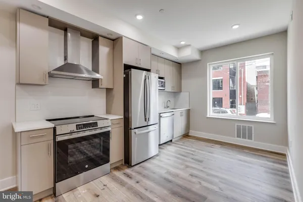 a kitchen with a stove a refrigerator and a stove top oven