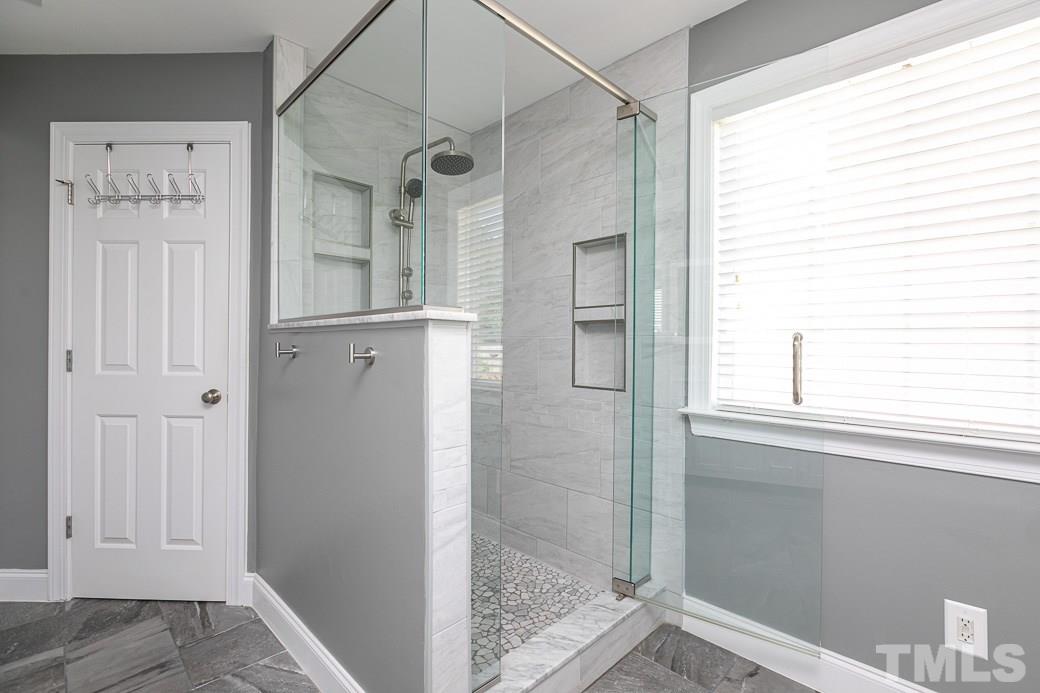 108 Quarryrock Road Holly Springs, NC 27540 - Photo 11 of 30 a bathroom with a glass shower door and a bathtub
