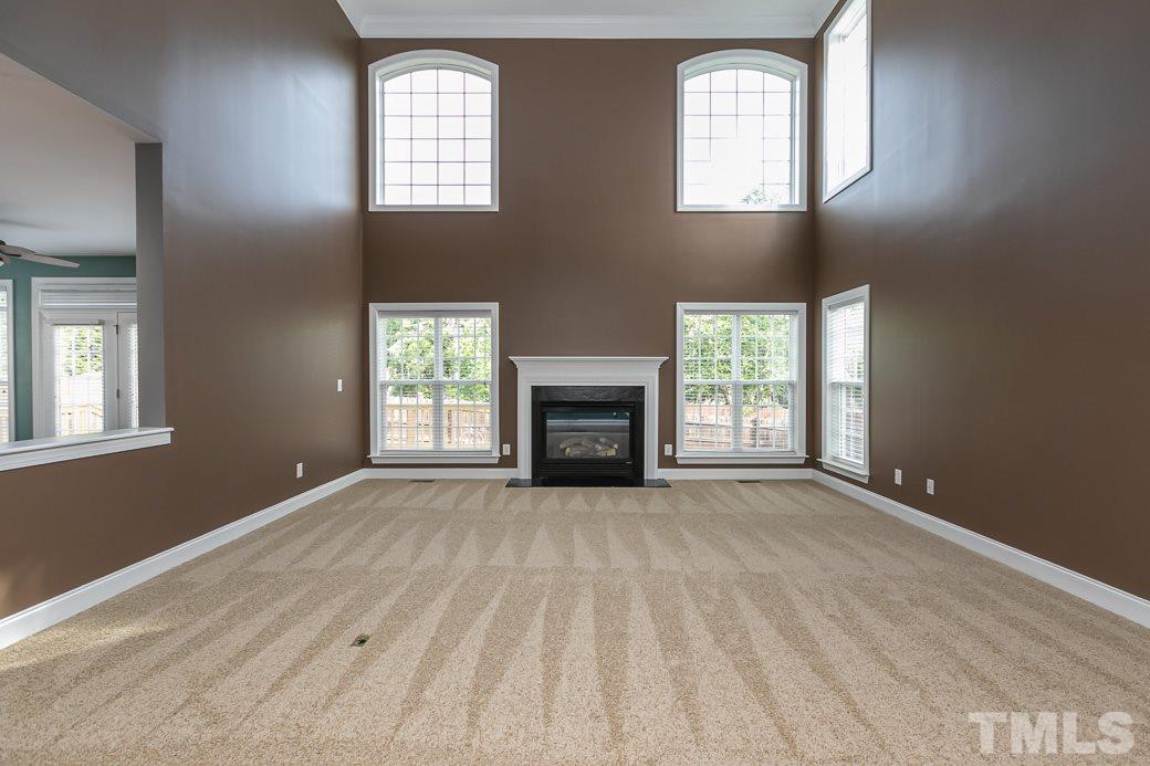 108 Quarryrock Road Holly Springs, NC 27540 - Photo 12 of 30 an empty room with windows fireplace and mirror