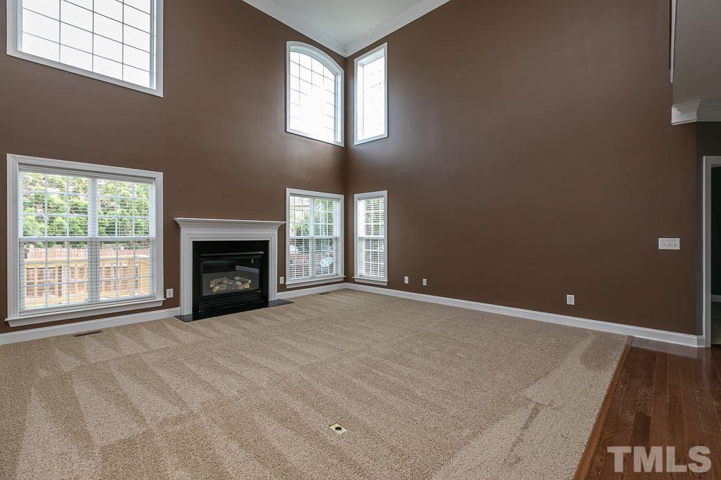 108 Quarryrock Road Holly Springs, NC 27540 - Photo 13 of 30 an empty room with windows and fireplace