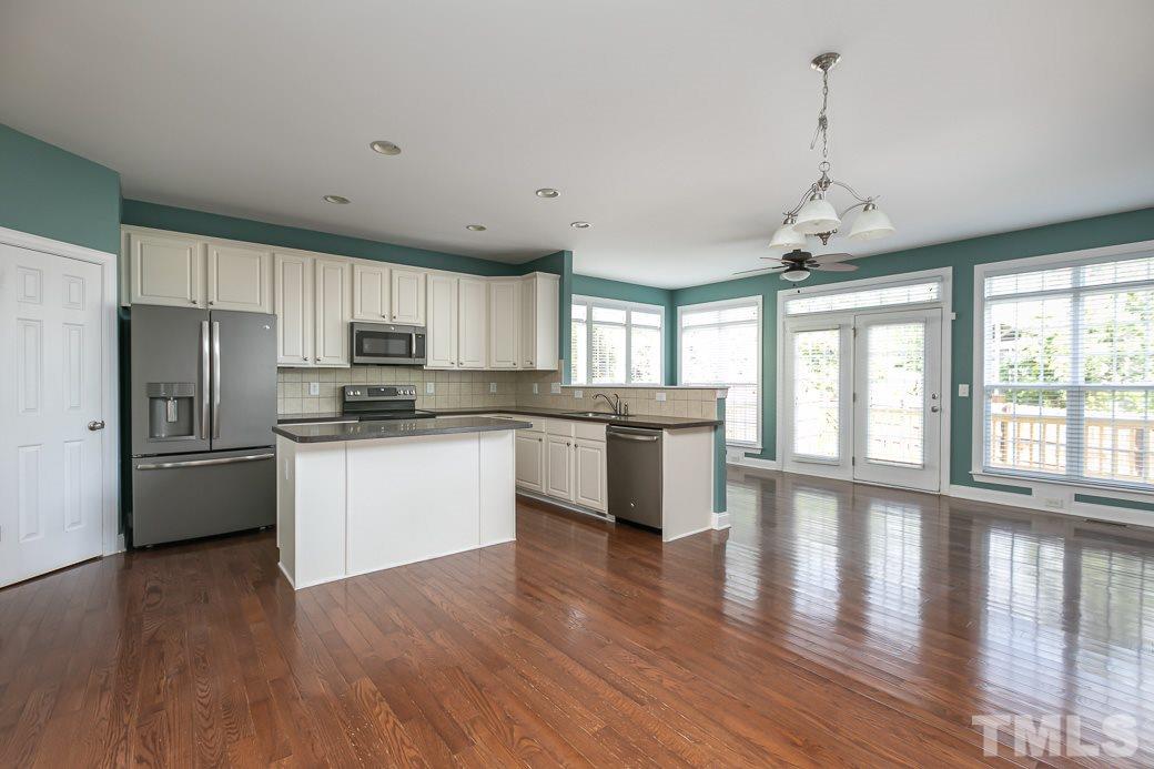 108 Quarryrock Road Holly Springs, NC 27540 - Photo 3 of 30 a large kitchen with cabinets wooden floor and stainless steel appliances