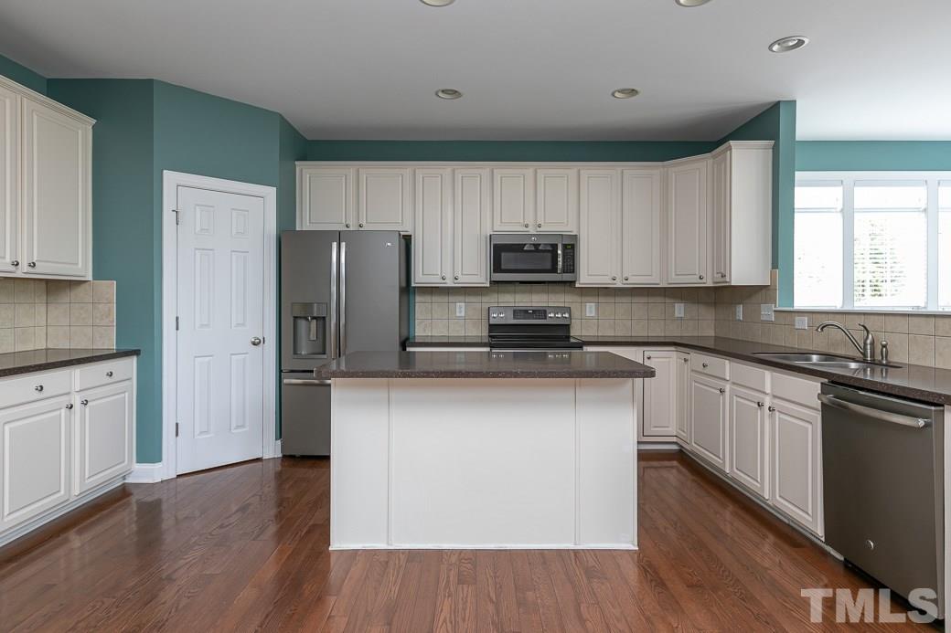 108 Quarryrock Road Holly Springs, NC 27540 - Photo 5 of 30 a kitchen with stainless steel appliances a refrigerator sink and microwave