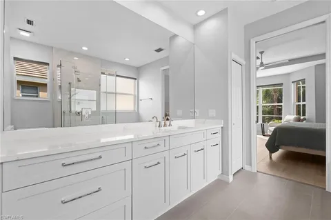 a bathroom with a tub a sink and a large mirror