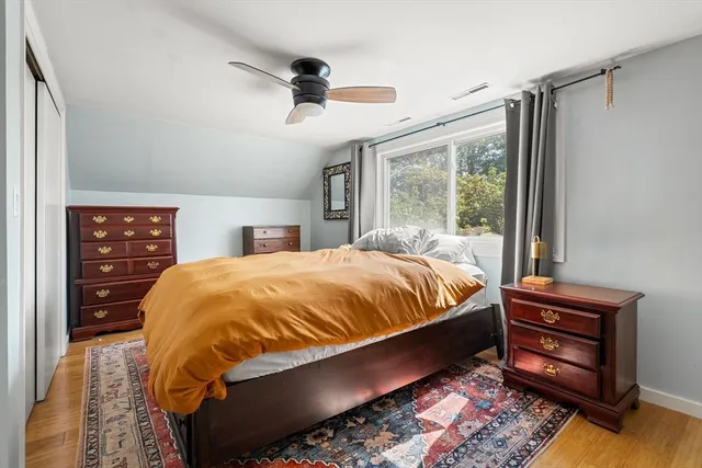a bedroom with a bed and a dresser next to a window