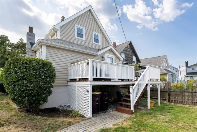 a view of a house with a wooden deck and furniture