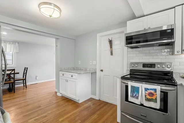a kitchen with granite countertop a stove and a microwave
