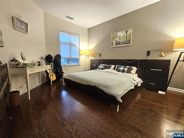 a bedroom with a bed and wooden floor