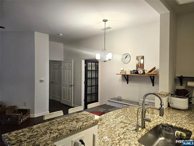 a kitchen with stainless steel appliances granite countertop a sink a stove and a wooden floors