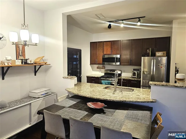 a kitchen with a sink refrigerator and microwave