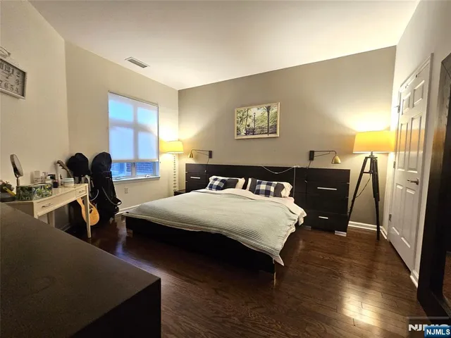 a bedroom with bed and wooden floor