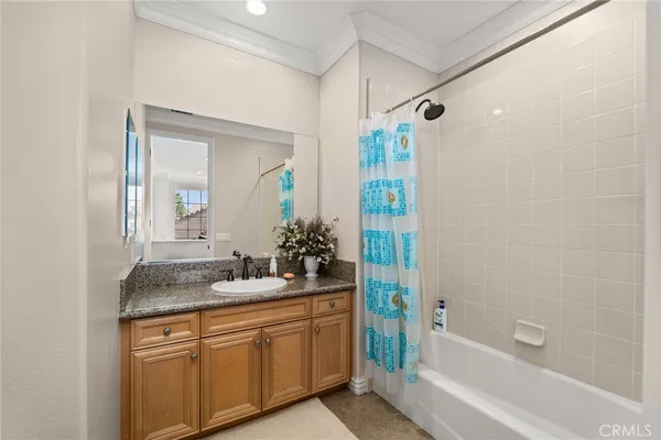 a bathroom with a granite countertop sink and a toilet