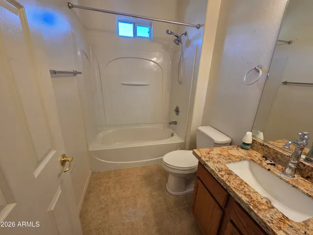 an empty room with ceiling fan and windows