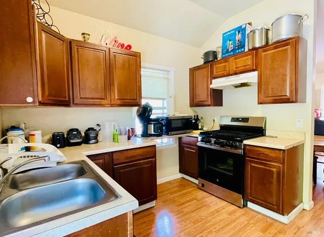 a kitchen with stainless steel appliances granite countertop a stove and a sink