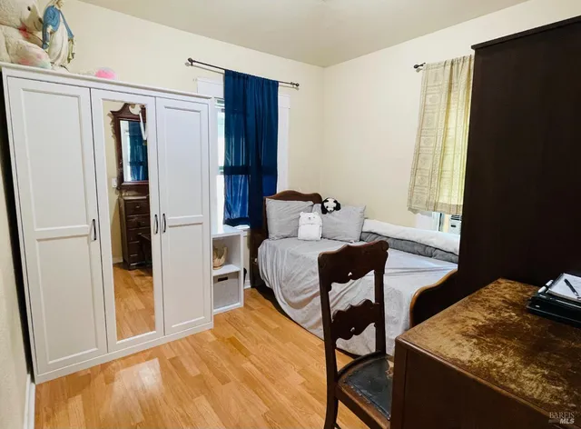 a bedroom with a bed and wooden floor