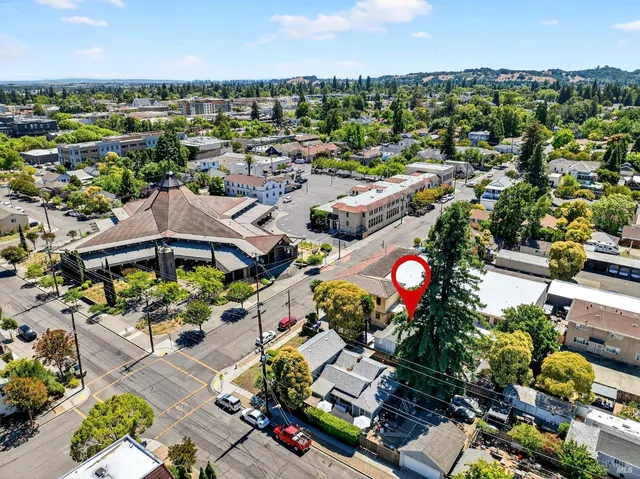 an aerial view of residential houses with outdoor space and parking