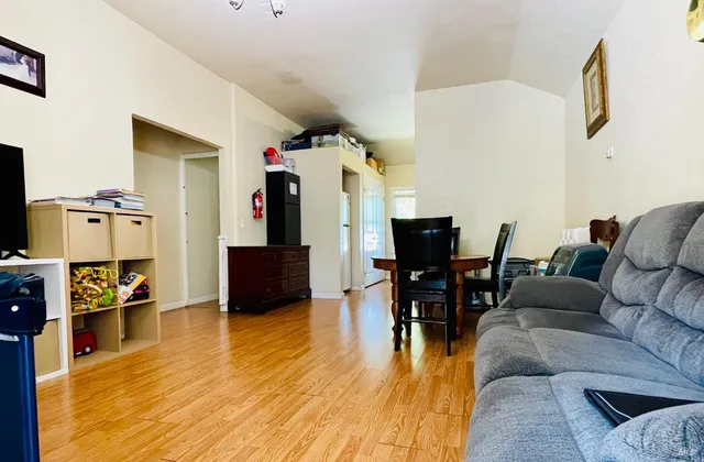 a living room with furniture and a wooden floor