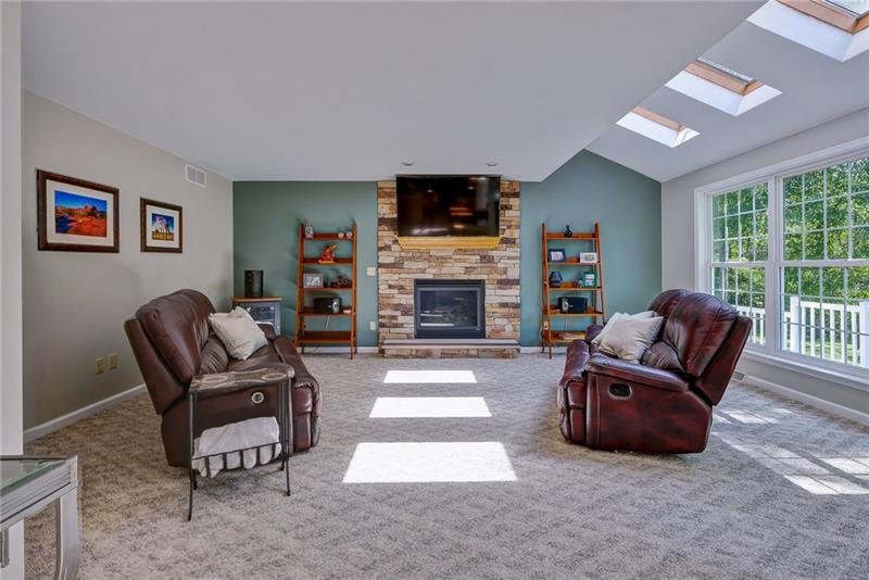 130 West Cruikshank Road Butler, PA 16002 - Photo 10 of 25 Light filled family room with floor to ceiling windows, skylights and stone surround, gas fireplace.