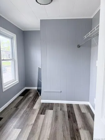 a view of a room with wooden floor and a window