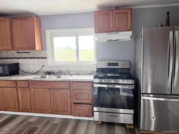 a kitchen with granite countertop a refrigerator stove and sink