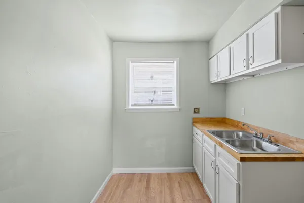 a view of empty room with window and wooden floor