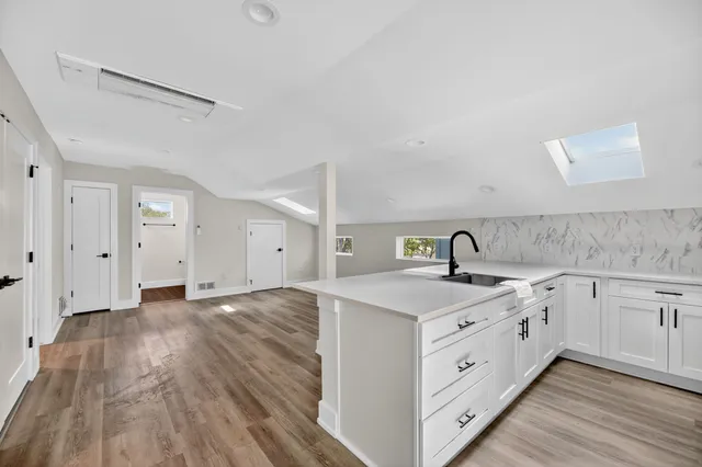 a kitchen with a sink cabinets and wooden floor
