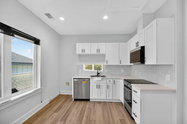 a kitchen with a sink appliances and cabinets