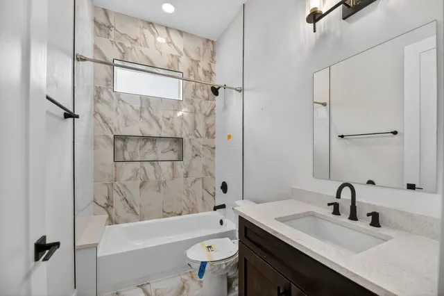 a bathroom with a granite countertop sink toilet and shower