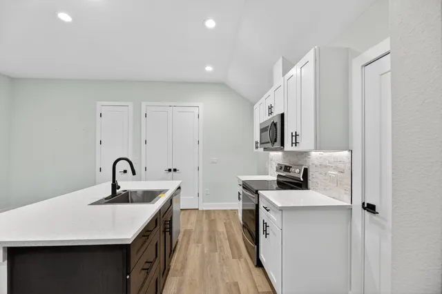 a kitchen with a sink stove and cabinets