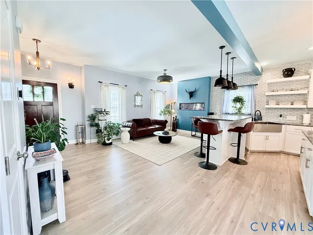 a kitchen with stainless steel appliances kitchen island granite countertop a sink cabinets and wooden floor